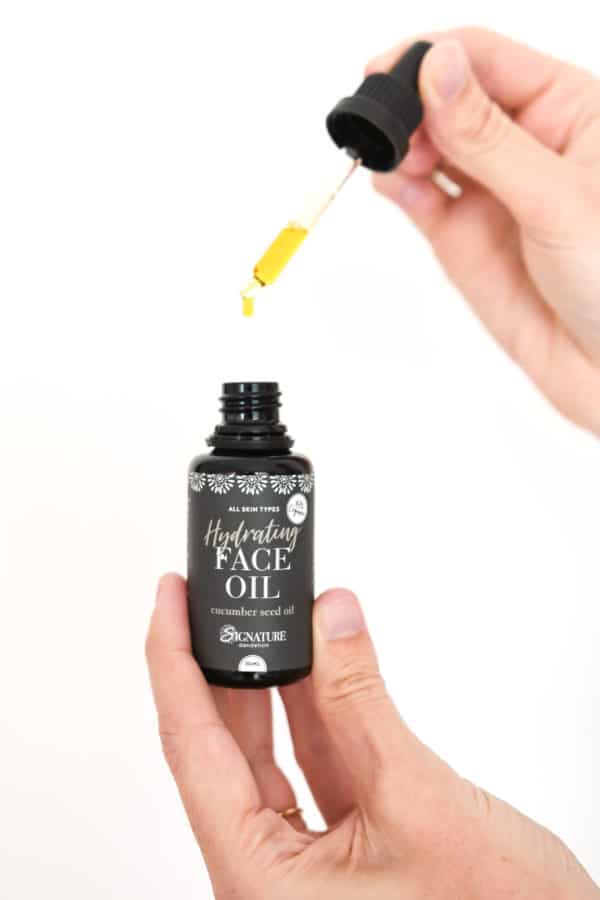 woman holding dropper of hydrating face oil