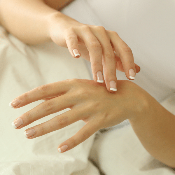 female applying body oil to hands
